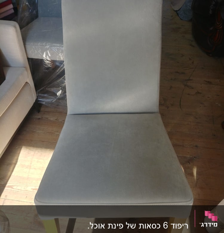 כיסא מרופד בבד אפור על רצפת עץ